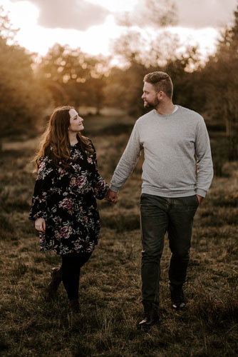 Jenny & Chris euer Fotografenpaar – Hand in Hand in der Abendsonne sich verliebt anschauend